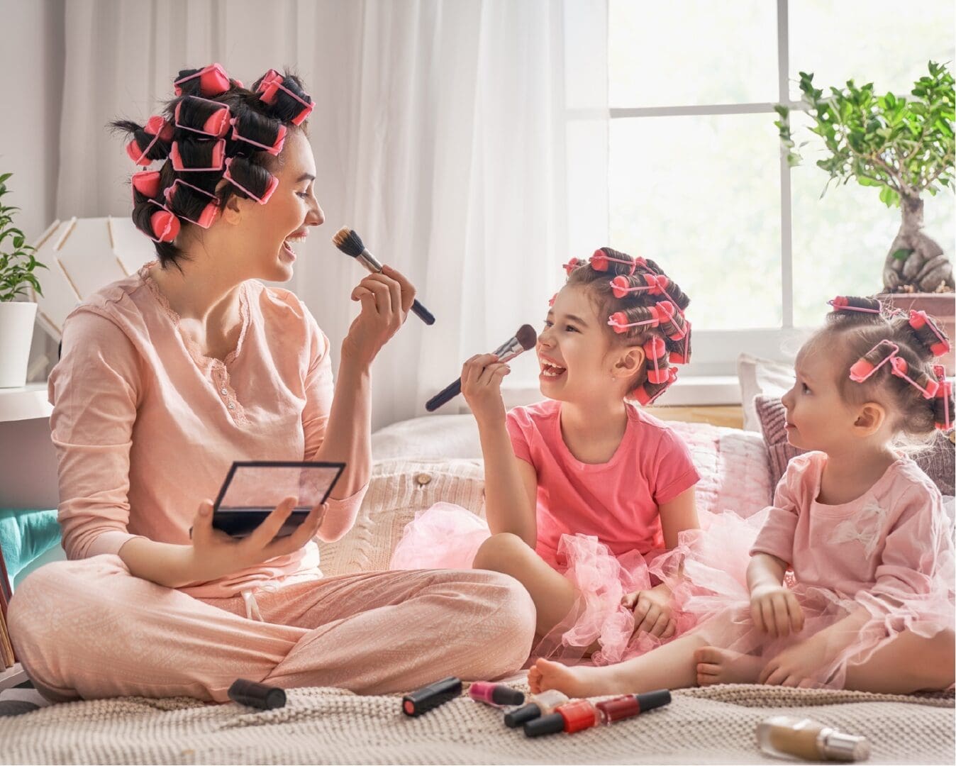 A children's book author captures a fresh perspective in her latest work featuring a mother and her two daughters sitting on a bed with curlers in their hair.